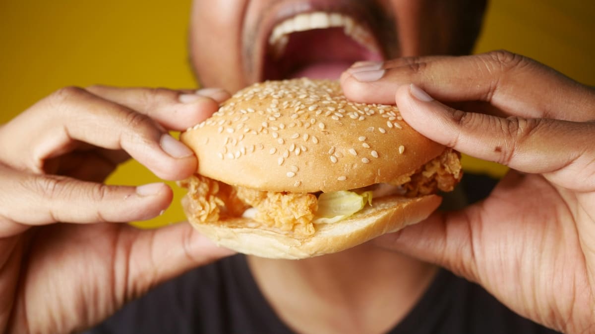 homme mangeant un burger