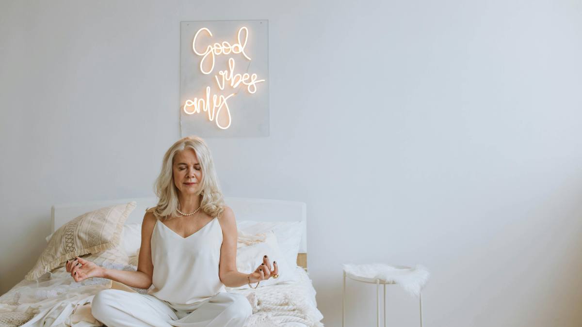 Femme qui fait de la m&eacute;didation sur son lit